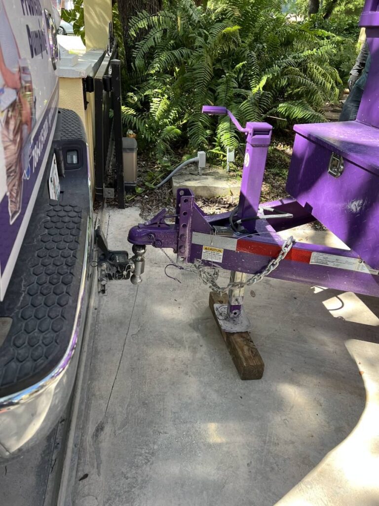 Wood block under a dumpster trailer jack to protect a finished driveway