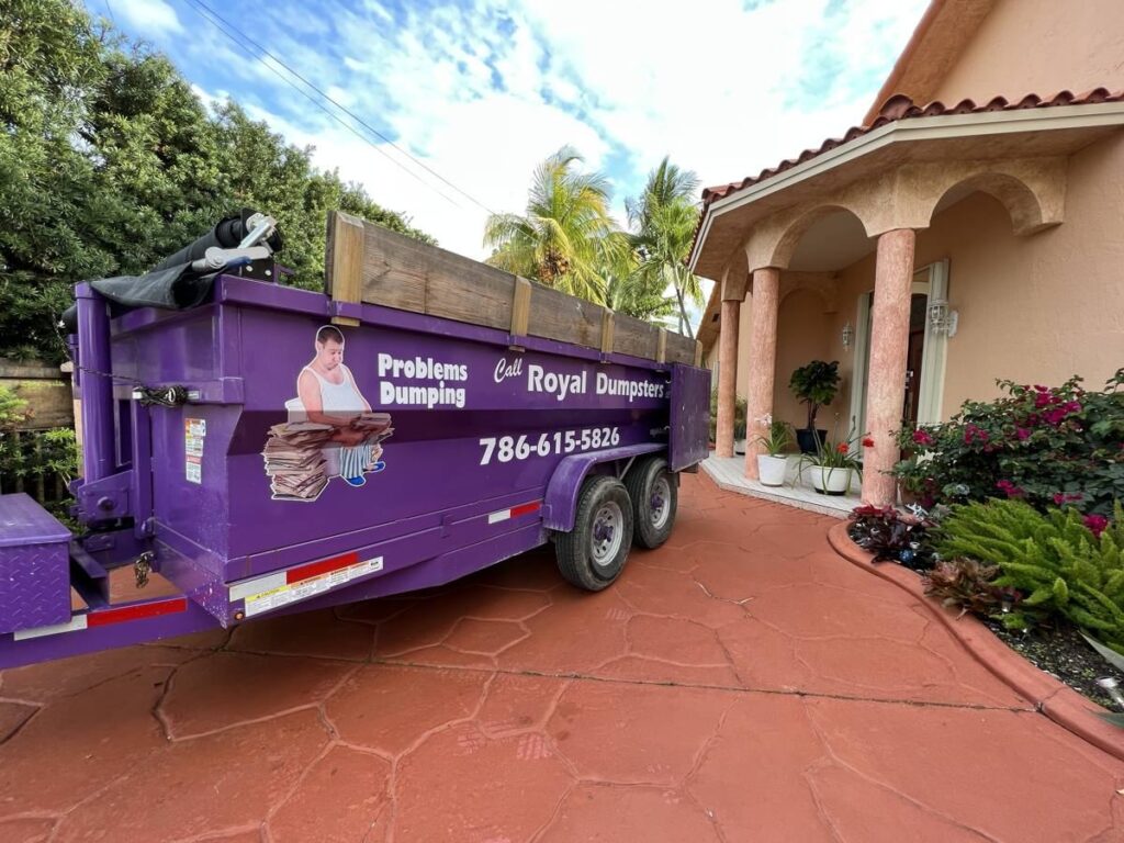 Purple dumpster on a finished stamped-concrete driveway in Bay Harbor Islands, FL