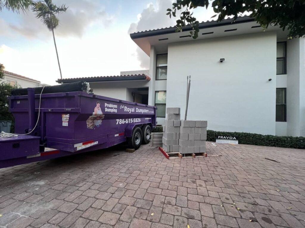 Purple dumpster on a paver driveway in Miami Beach, FL